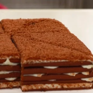 Rebanadas de pastel de chocolate con capas de crema y cobertura de cacao